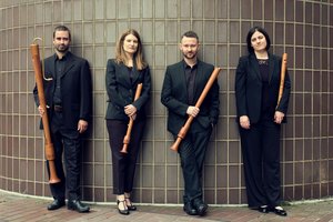 The Flautadors standing against a ceramic wall, holding recorders